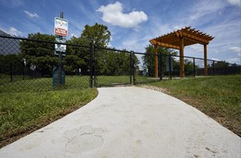 A sign on a pole in front of a fence reads "No Parking".
